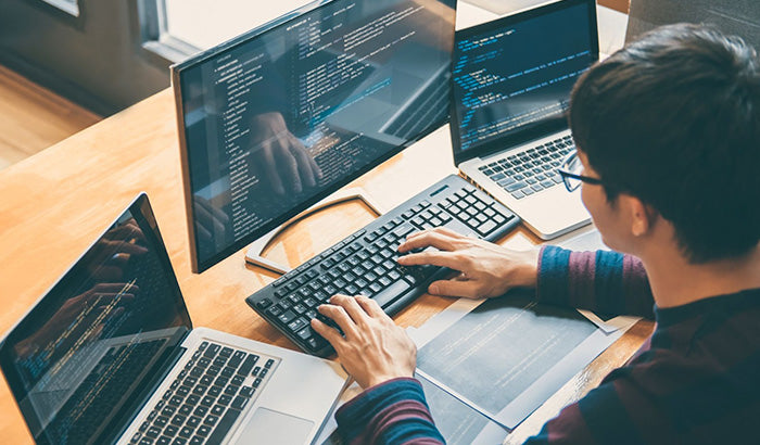 A man working on his computer with two monitors using Autodesk AutoCAD Software for electrical design